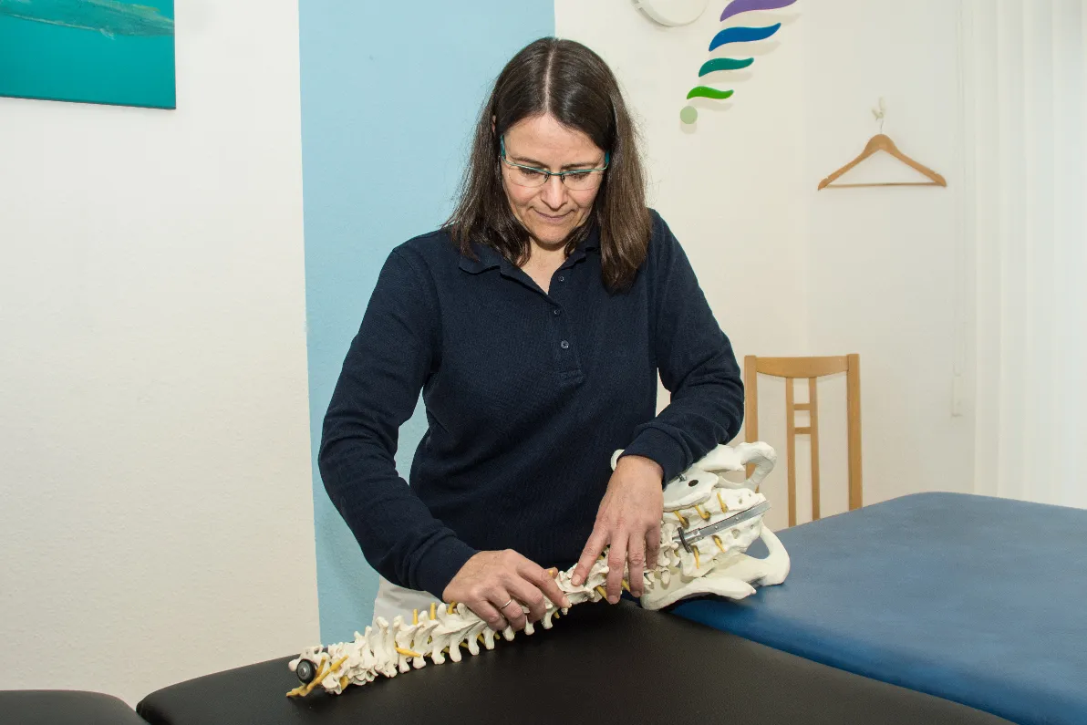 Petra Hasselhoff-Styhler, Inhaberin von radius physiotherapie, bei der Arbeit am Wirbelsäulenmodell